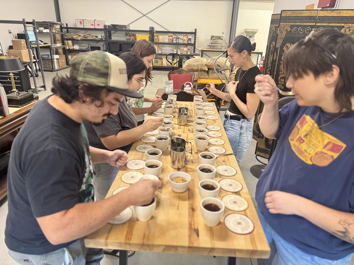 Cuppers tasting coffee around the cupping table at Sanctuary Coffee Roasting Company in Clovis, California