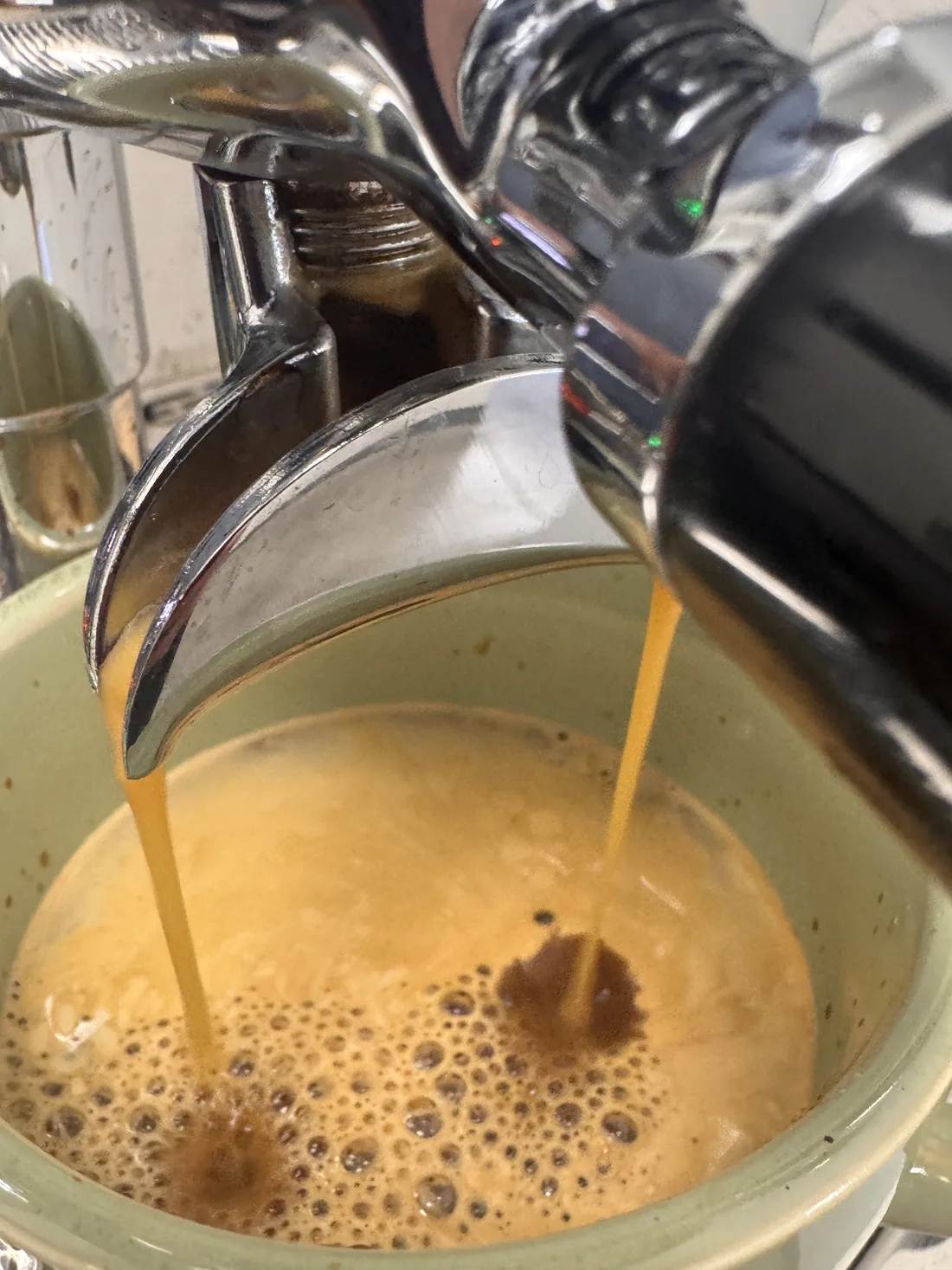 A double shot of espresso pouring into a ceramic cup at the Sanctuary roastery
