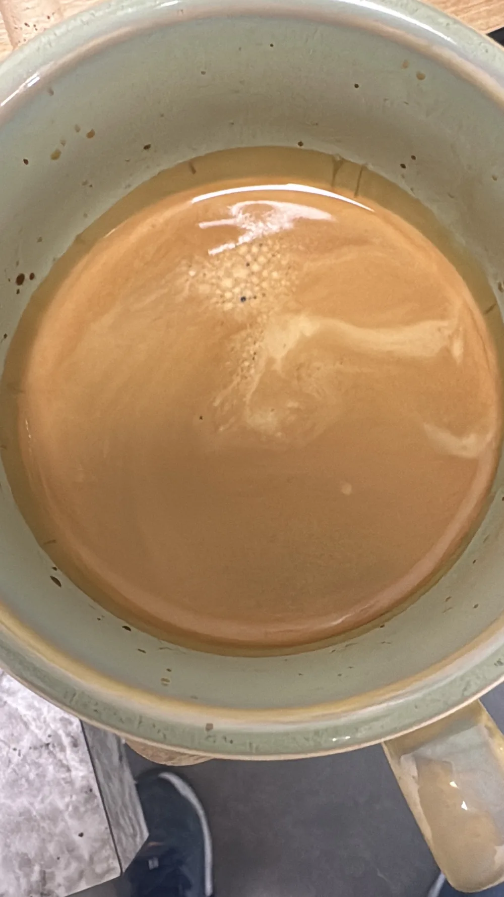 A finished cup of freshly roasted coffee with an even crema, photographed from above