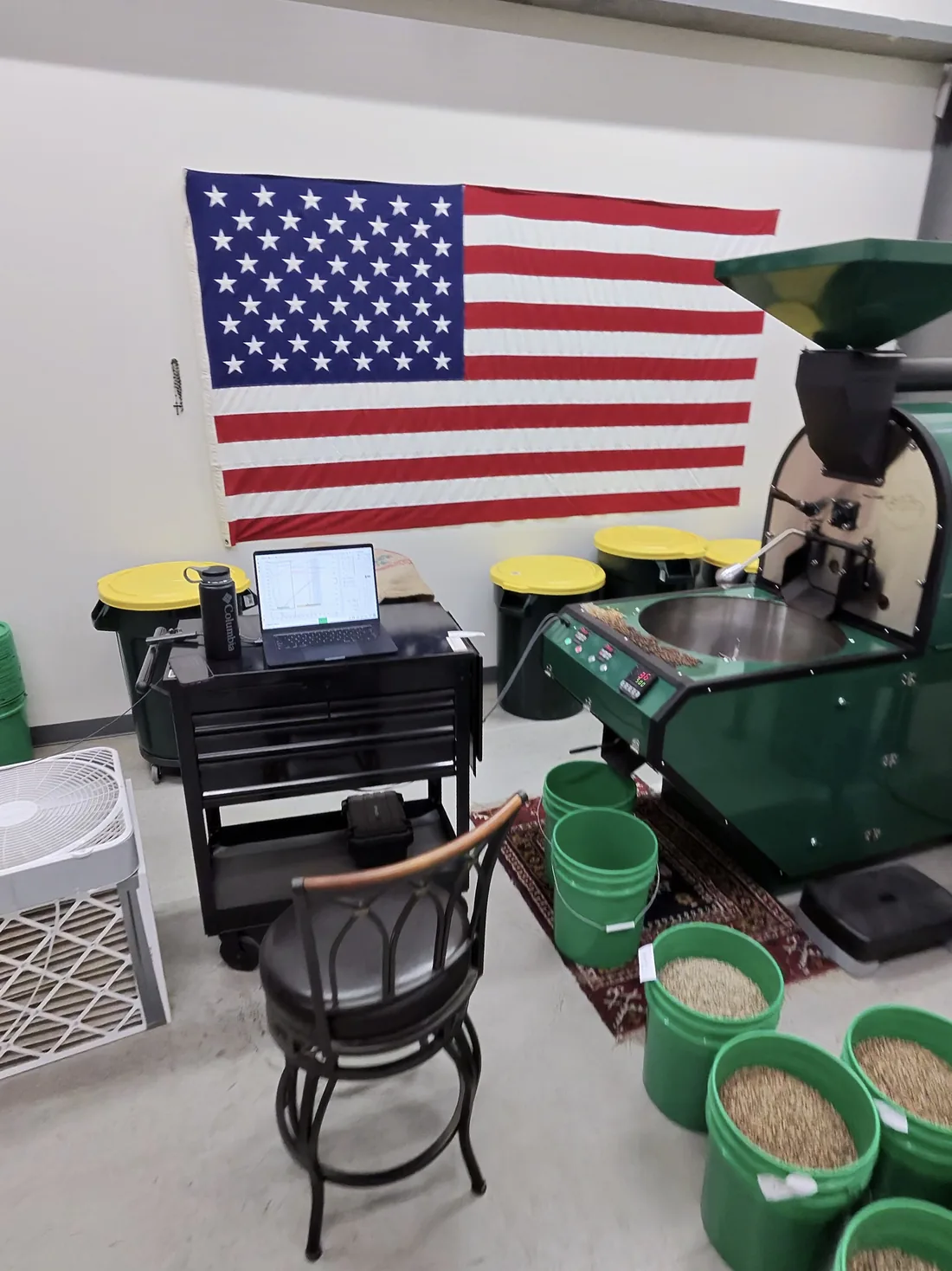 Vatche Moukhtarian's coffee roaster and roast profile laptop under an American flag at Sanctuary Coffee Roasting in Clovis